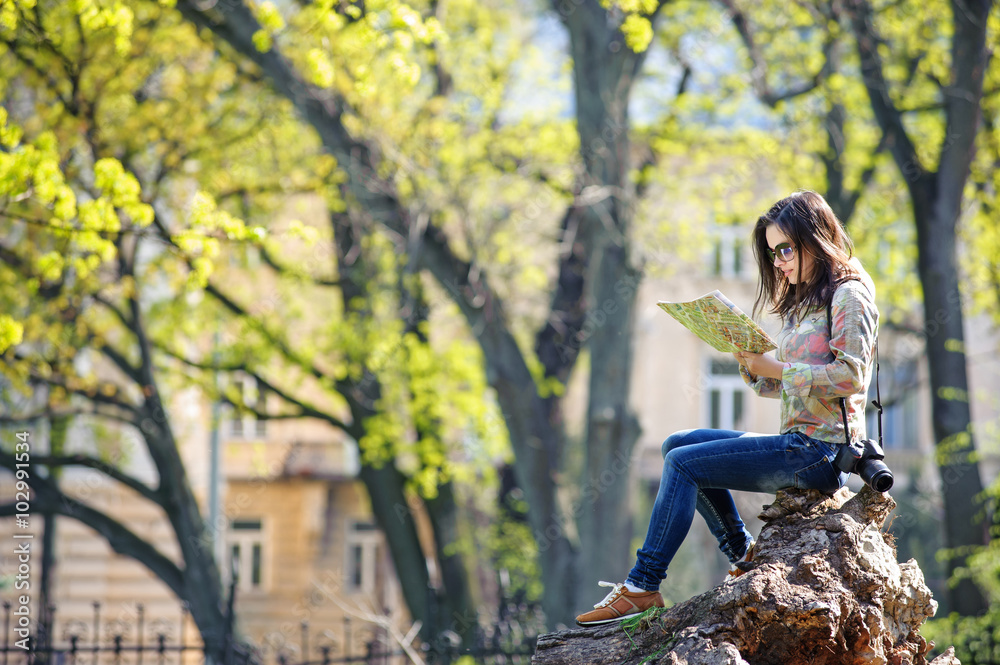 young girl sitting in the park and reading a map young girl sitting in the park and reading a map