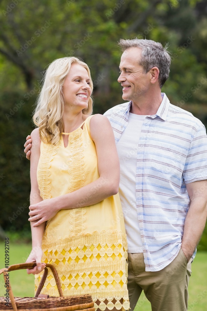 Naklejka premium Happy couple holding picnic basket