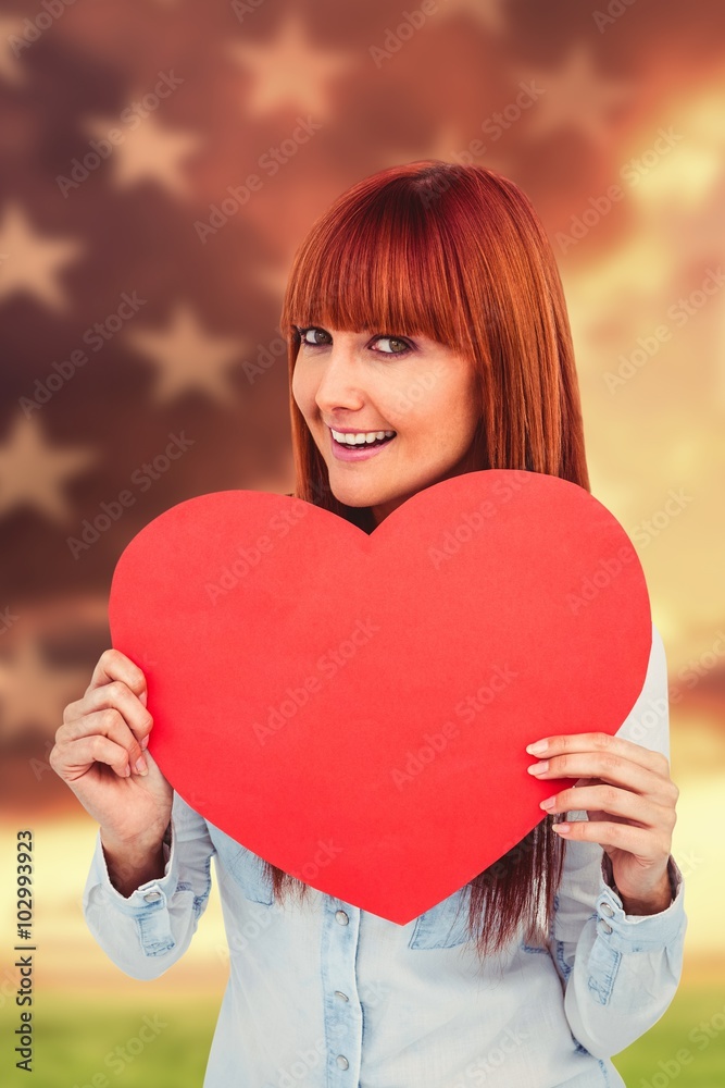 Composite image of attractive hipster woman behind a red heart Composite image of attractive hipster woman behind a red heart