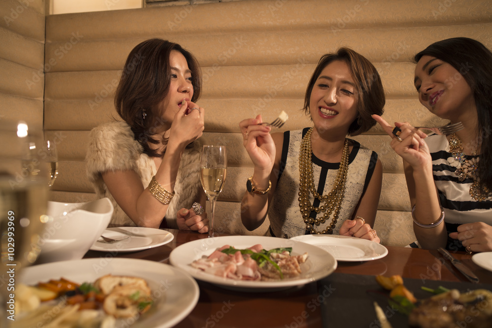 Three women laughing while dining in the restaurant