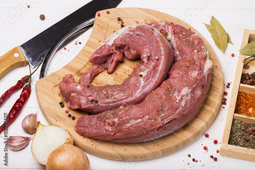 Fototapeta Naklejka Na Ścianę i Meble -  Pork tenderloin on a cutting board with ingredients