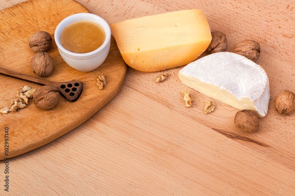 Cheese, walnuts, honey on a wooden table Cheese, walnuts, honey on a wooden table