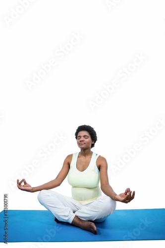 Pregnant woman meditating on mat