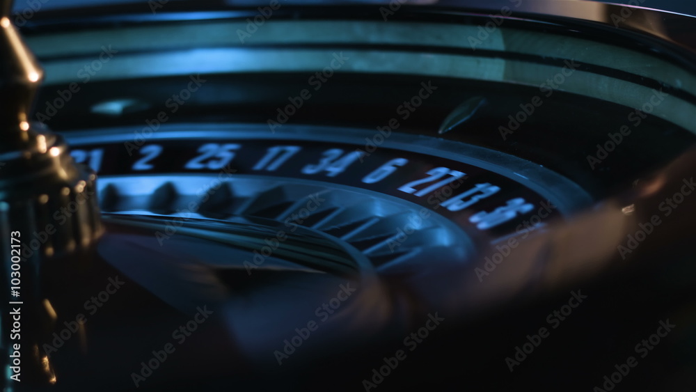 Close-up footage of white ball is spinning in a russian roulette wheel and then gets into a slot at a game table in casino. 
