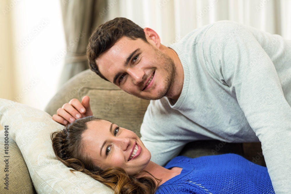 Portrait of young couple cuddling on sofa Portrait of young couple cuddling on sofa