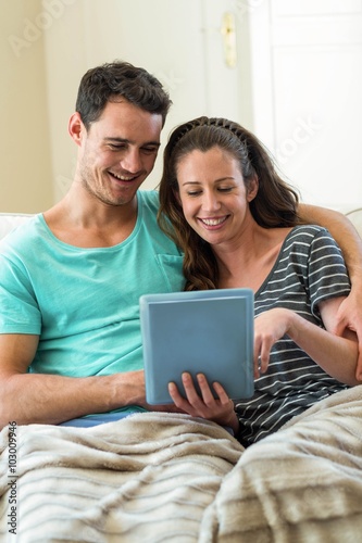 Young couple using a digital tablet on sofa