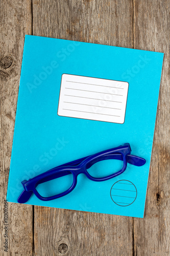 Blue exercise book and glasses