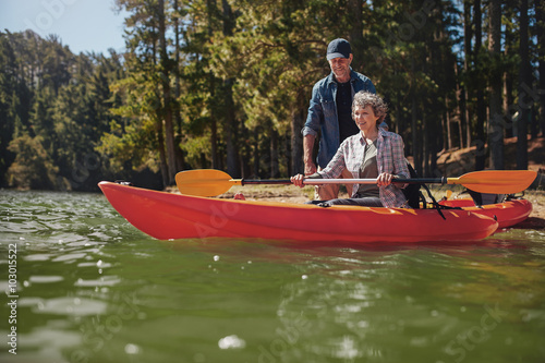 Senior woman getting kayaking lessons from a man