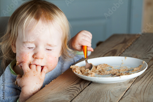 baby eating porridge at the table