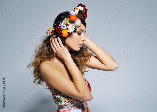 Beauty portrait of a gorgeous woman with gypsy hairstyle wearing handmade fairy flower crown .