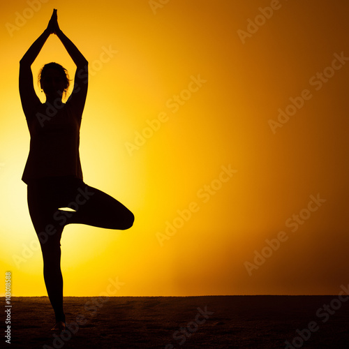 The woman practicing yoga in the sunset light
