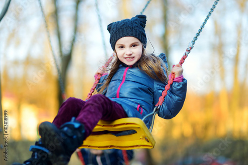 Cute little girl having fun on a swing