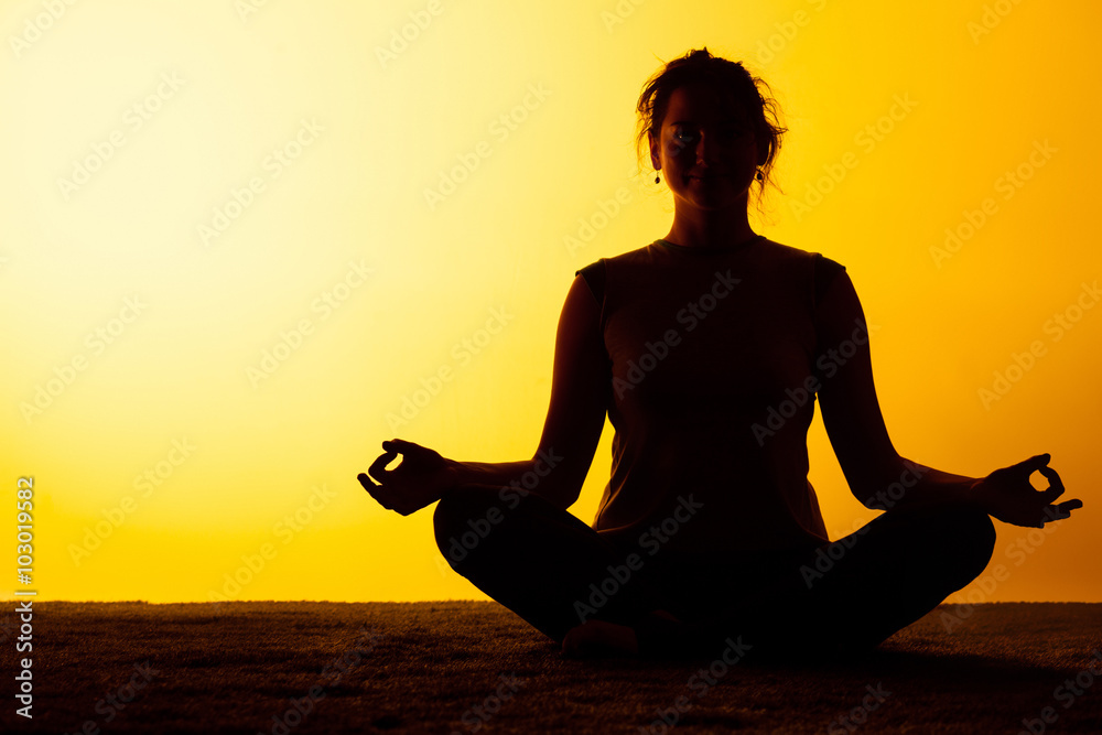 The woman practicing yoga in the sunset light The woman practicing yoga in the sunset light
