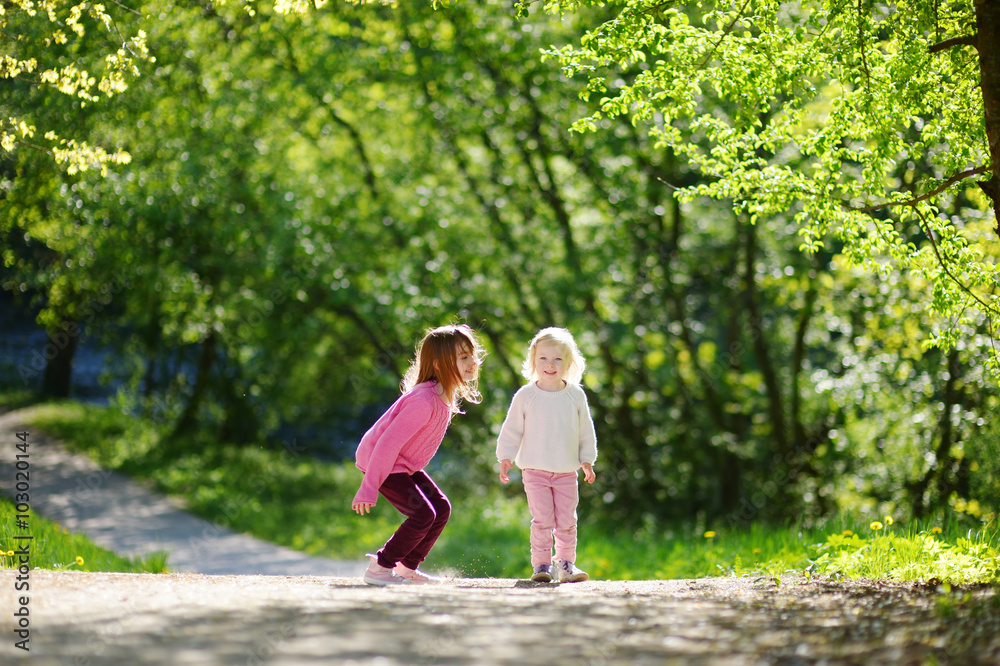 Two adorable little sisters laughing and jumping Two adorable little sisters laughing and jumping