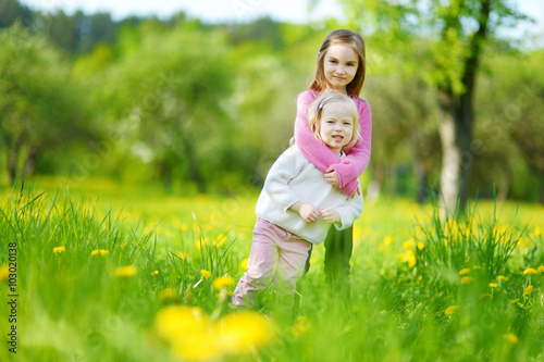 Fotografi Two adorable little sisters laughing and hugging