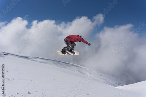 Flying snowboarder on mountains. Extreme sport.