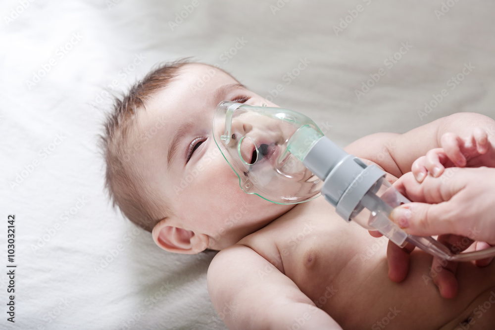 Doctor makes inhalation to a sick little baby.
