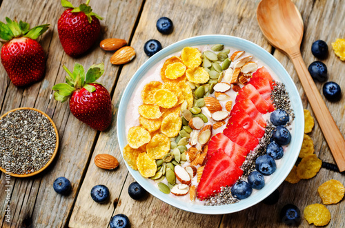 healthy strawberry smoothie bowl with fruits, cereals, seeds and