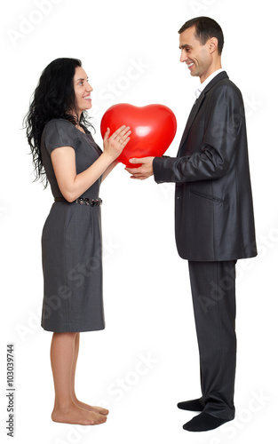 Happy couple portrait with red heart shaped balloon. Valentine holiday concept. Studio isolated