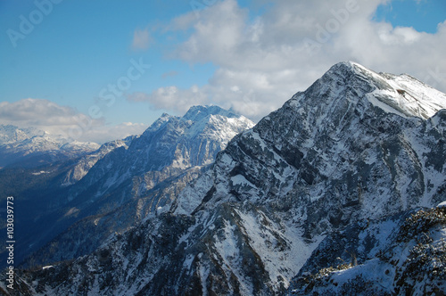 Beautiful snow-capped mountains against the blue sky  Panorama of mountain peaks with white clouds