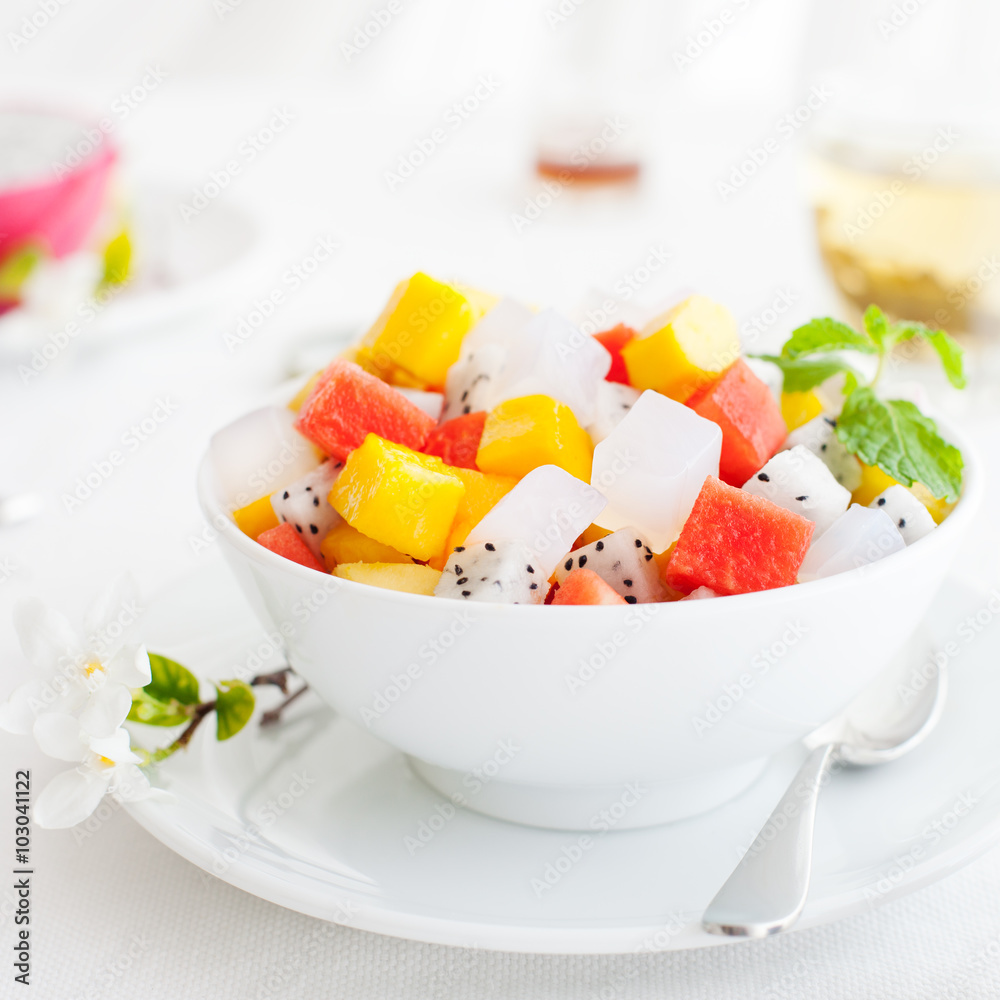Bowl of fresh exotic fruit salad on white summer background Healthy breakfast Bowl of fresh exotic fruit salad on white summer background Healthy breakfast