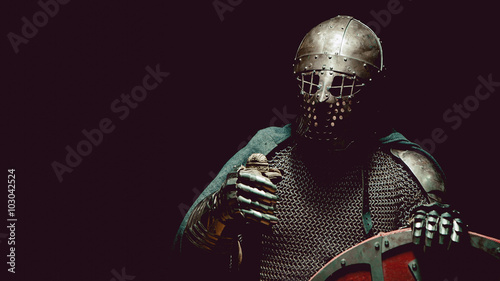 Medieval knight in the armor with the sword and shield.