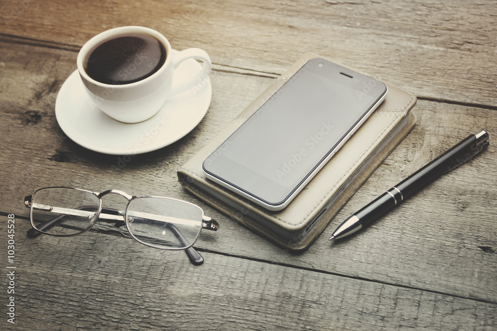 coffee, phone, notebook, pen and glass coffee, phone, notebook, pen and glass
