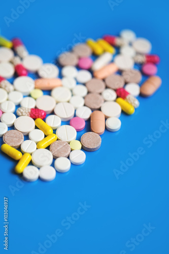Pills heart on a blue background.