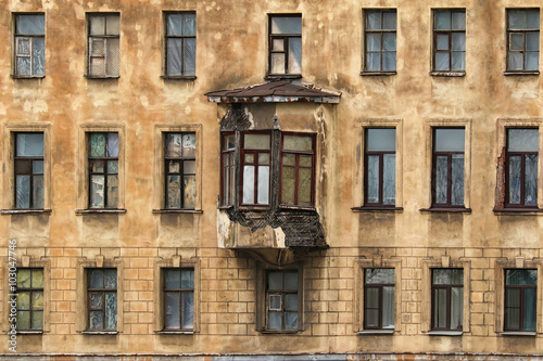 Many windows in row and bay window on facade of urban apartment building front view, St. Petersburg, Russia.