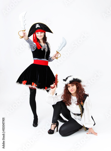 Two young women in pirate costumes on white background