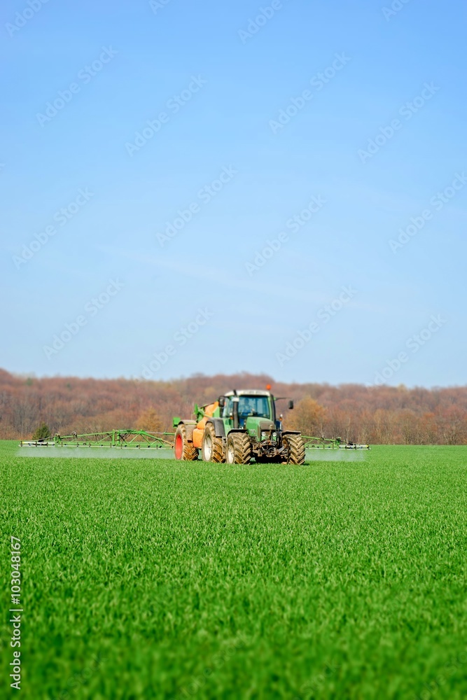 Traktor mit Feldspritze im Einsatz, Bildeffekt Traktor mit Feldspritze im Einsatz, Bildeffekt