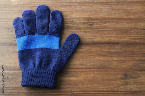 Kids Blue Striped Gloves on a wood background