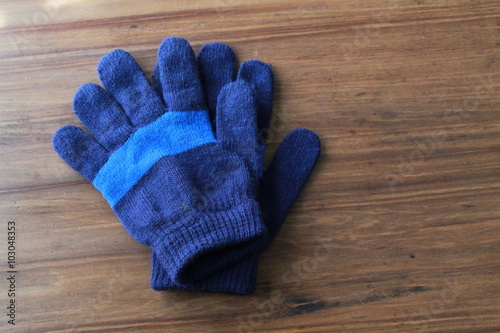 Kids Blue Striped Gloves on a wood background