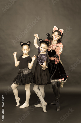 Episode of funny play in retro style. Three girls in cat costume