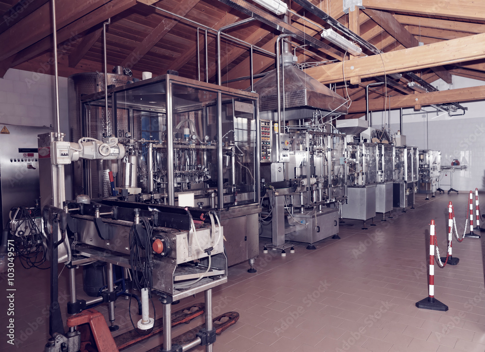 Wine bottling equipment line in a hangar, toned Wine bottling equipment line in a hangar, toned