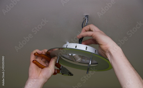 handyman installs chandelier