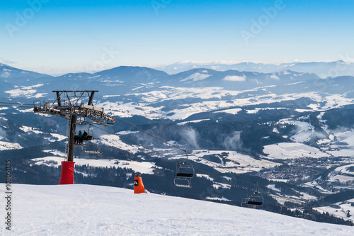 Chair lift on the top of  ski slope.
