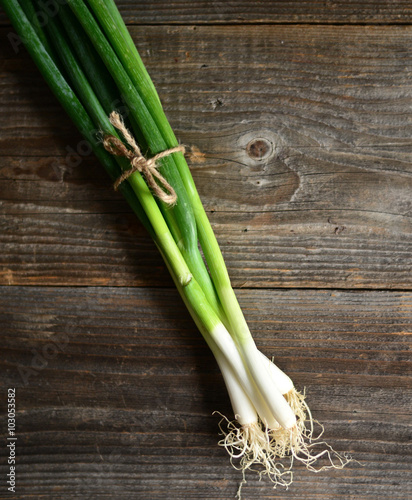 Bunch of spring onions on wood background