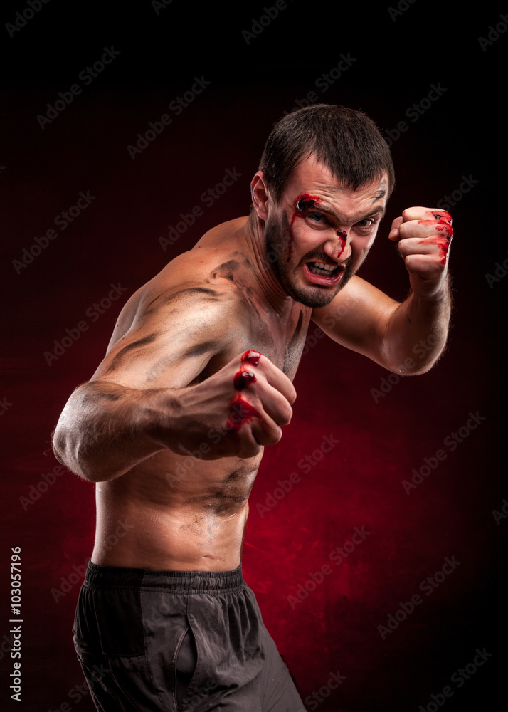 Fighter man. Boxer with blood on face and body. Aggressive man
