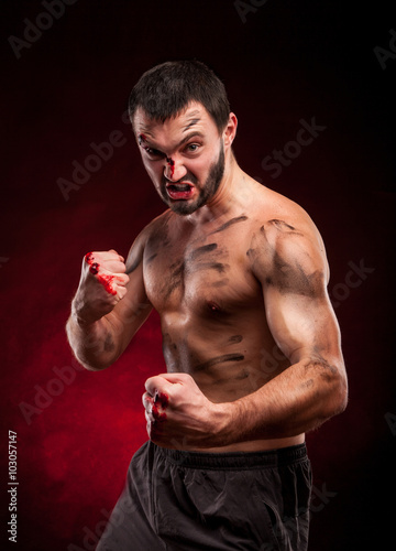 Fighter man. Boxer with blood on face and body. Aggressive man
