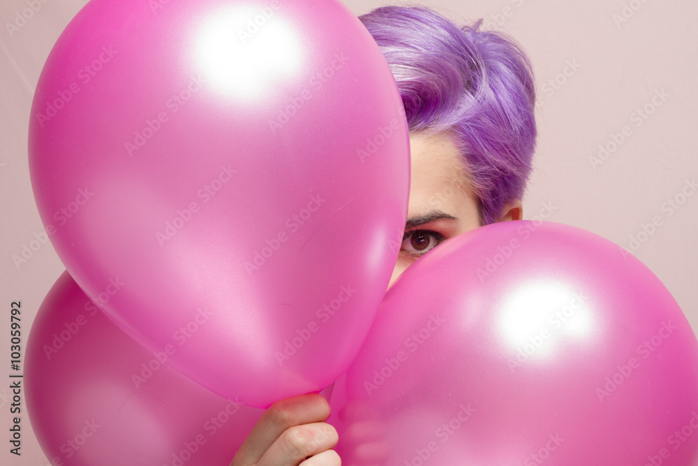 Violet short-haired girl in pink pastel peeking behind balloons Violet short-haired girl in pink pastel peeking behind balloons