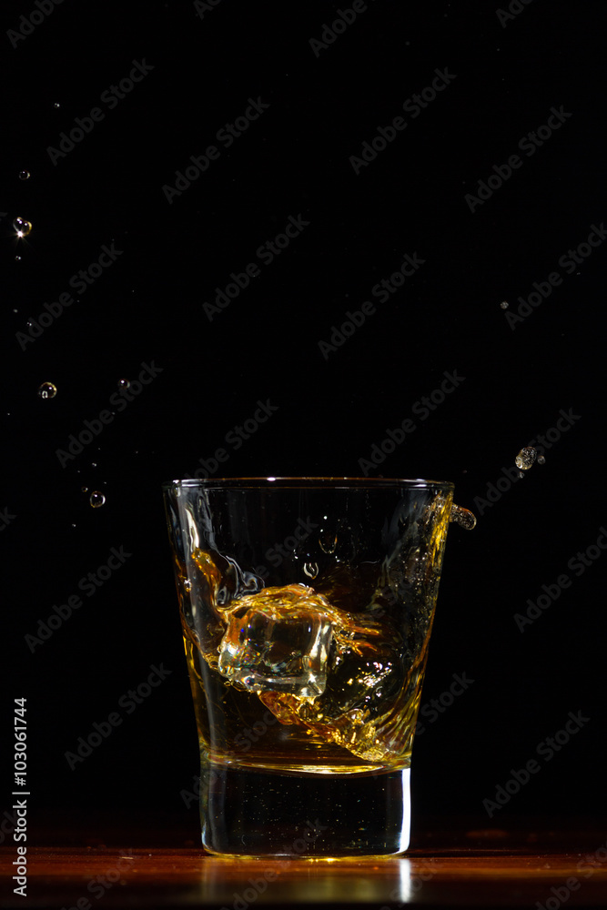Whiskey splash in glass on black Whiskey splash in glass on black