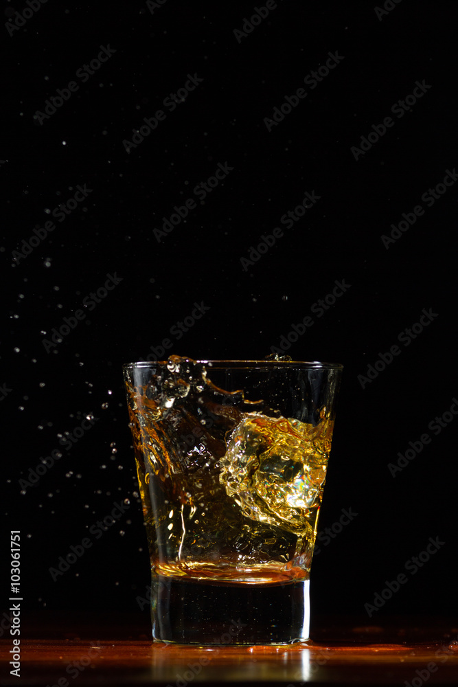 Whiskey splash in glass on black Whiskey splash in glass on black