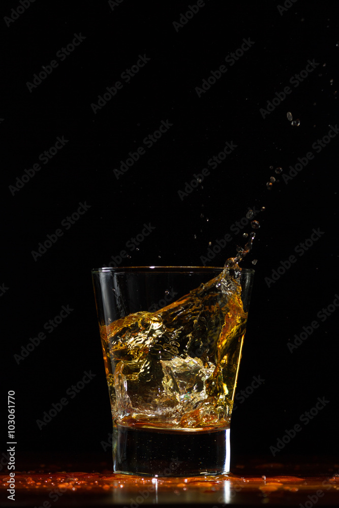 Whiskey splash in glass on black Whiskey splash in glass on black