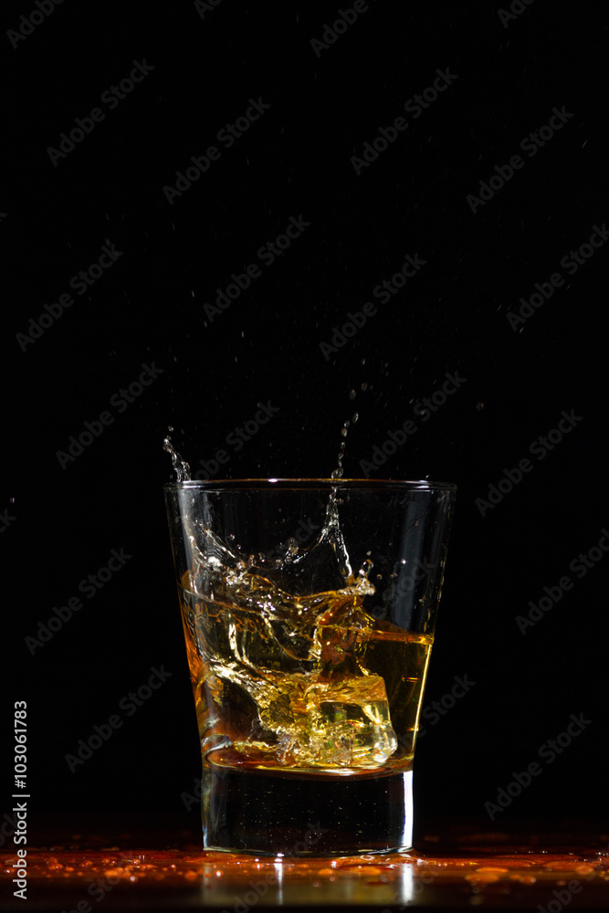 Whiskey splash in glass on black Whiskey splash in glass on black