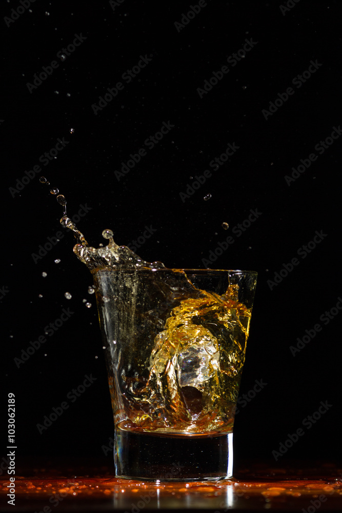 Whiskey splash in glass on black Whiskey splash in glass on black