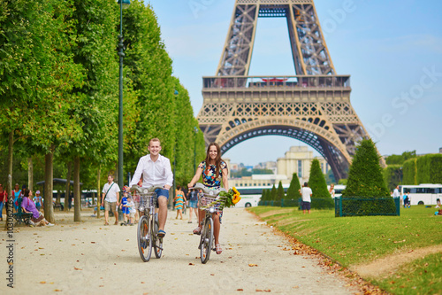 couple riding bicycles near the Eiffel tower in Paris © Ekaterina Pokrovsky
