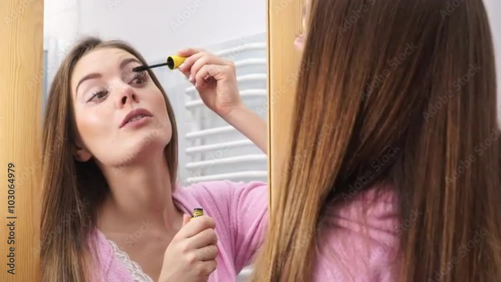 Woman applying black eye mascara to her eyelashes 4K Woman applying black eye mascara to her eyelashes 4K