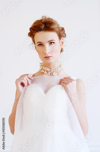 Young adult caucasian blond bride in white gown