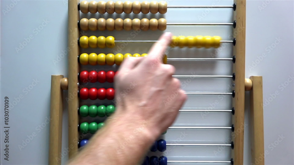 Man's hand moves the bones in the accounts of an abacus on white background